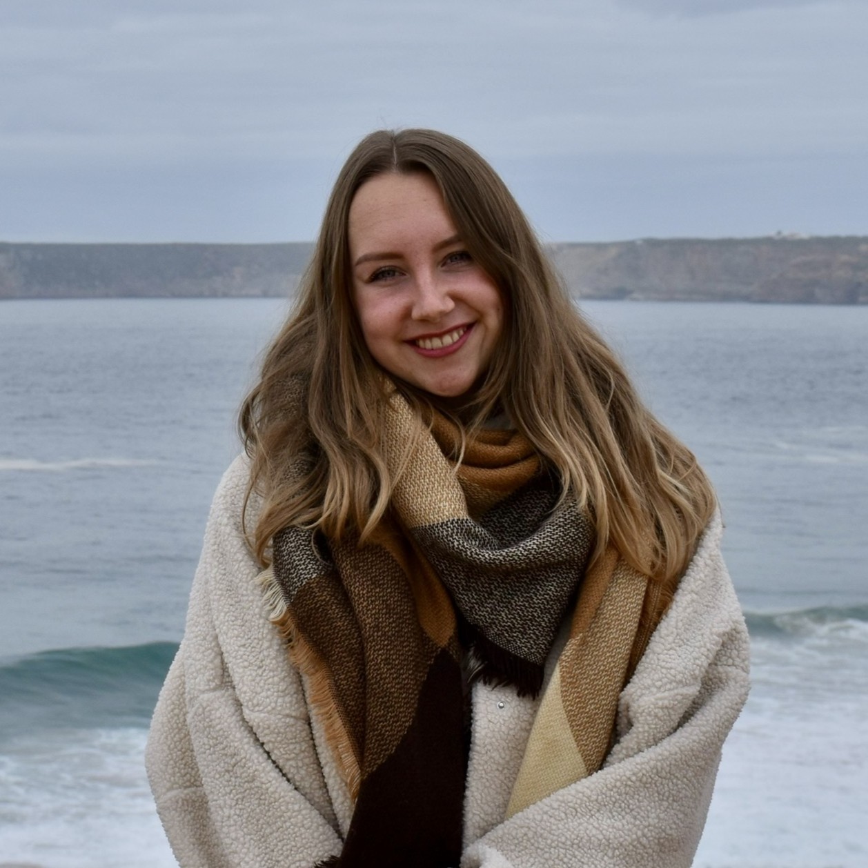 Portretfoto reisadviseur Kayleigh voor de kust van Portugal